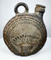 Dark-fired ceramic canteen with raised human face and feather-like ornament