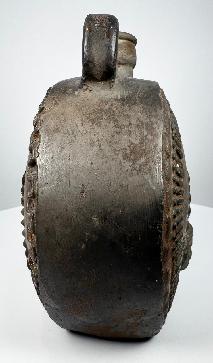 Ancient ceramic flask with feather-like relief motifs and dark-fired surface