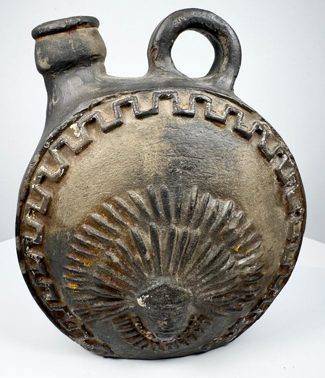 Circular Andean ceramic vessel with stylized face and ceremonial plumage motifs