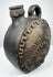 Blackware pottery canteen with integrated handle and anthropomorphic relief