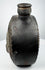 Pre-Columbian ceramic flask with stepped border surrounding a modeled face