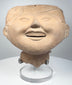 Ancient Mexican smiling face ceramic head from Veracruz with rounded cheeks and gently narrowed eyes