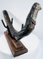 Prehistoric marine mammal rib fossil presented on a custom wood and metal display stand