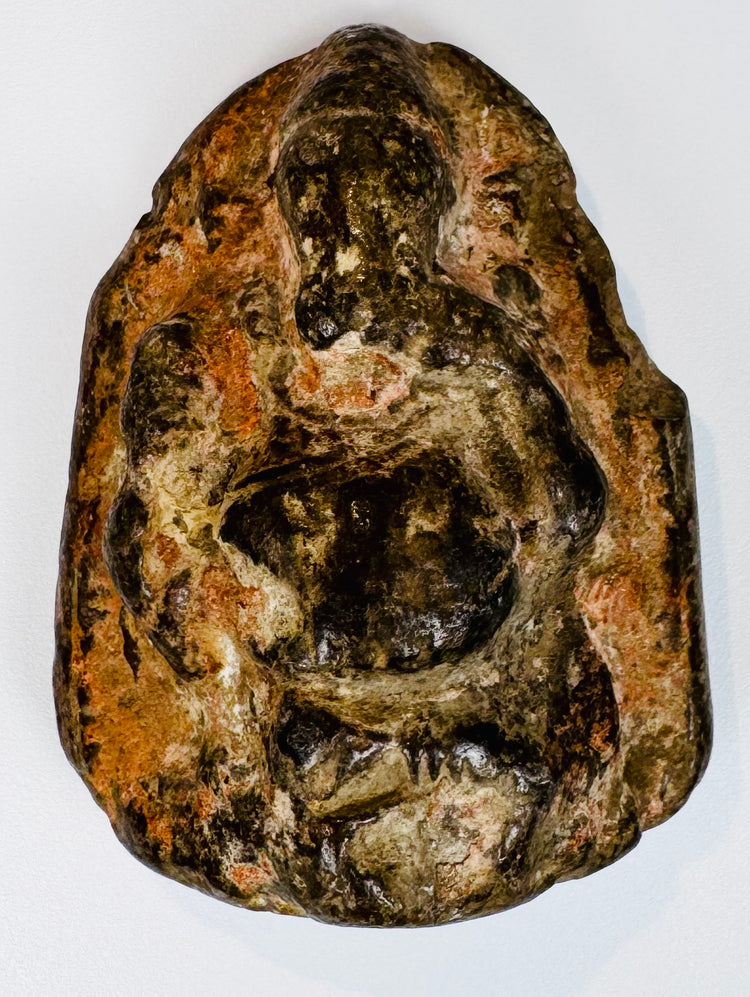 Indian religious stone sculpture of Ganesha with compact form and deeply carved surrounding details