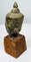 Ancient Thai Buddha head with downcast eyes, elongated face and extensive natural surface encrustation