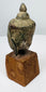Ancient Thai Buddha head with downcast eyes, elongated face and extensive natural surface encrustation