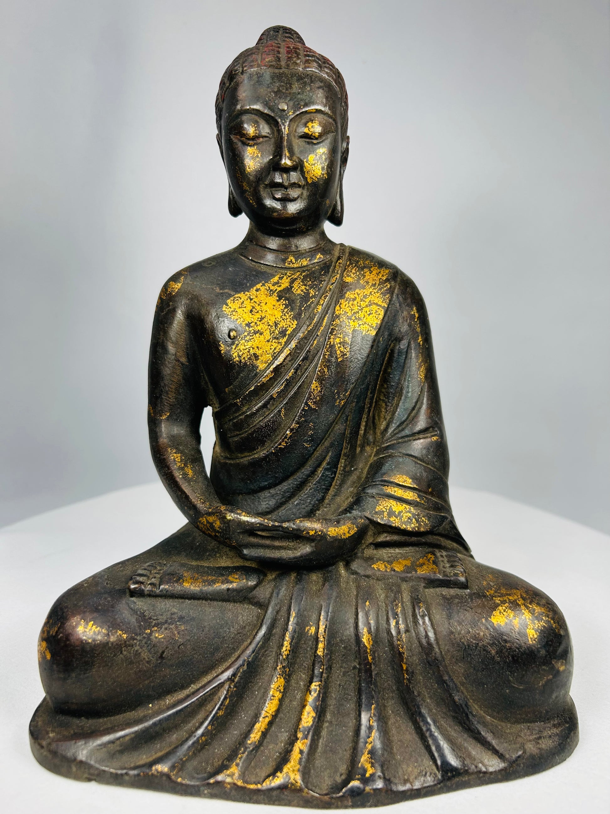Antique Chinese seated Buddha sculpture showing devotional wear and patina