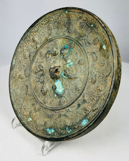 Tang Dynasty style bronze mirror featuring sea life and scrolling motifs