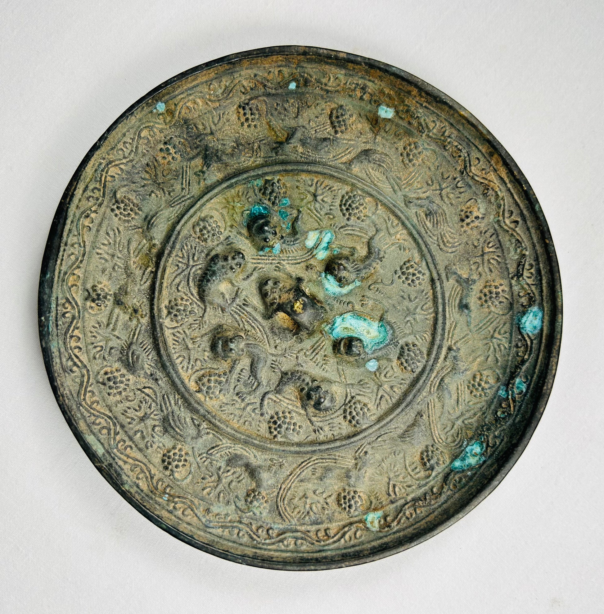 Chinese antique bronze mirror with ornate relief decoration on reverse
