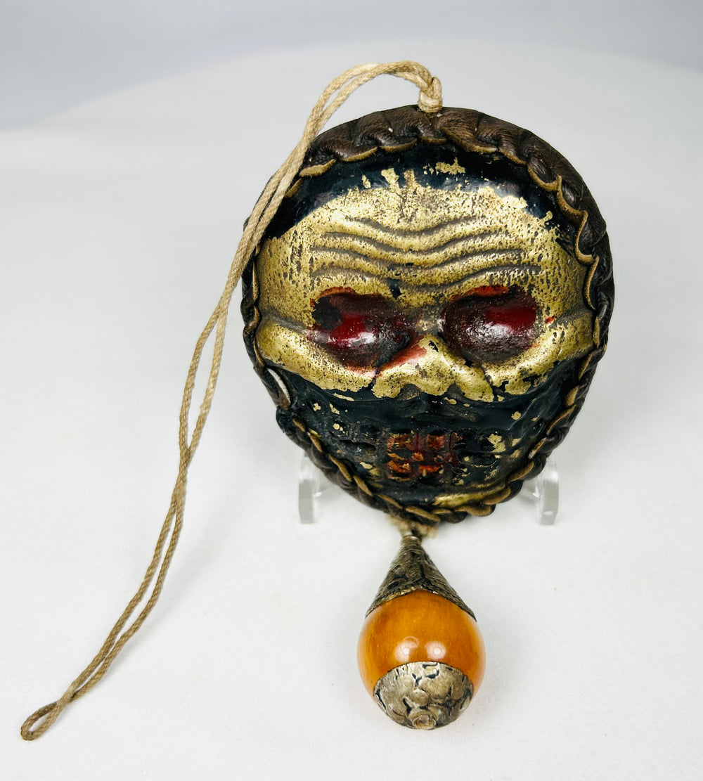 Himalayan skull-form ritual mask with amber-tone bead drop