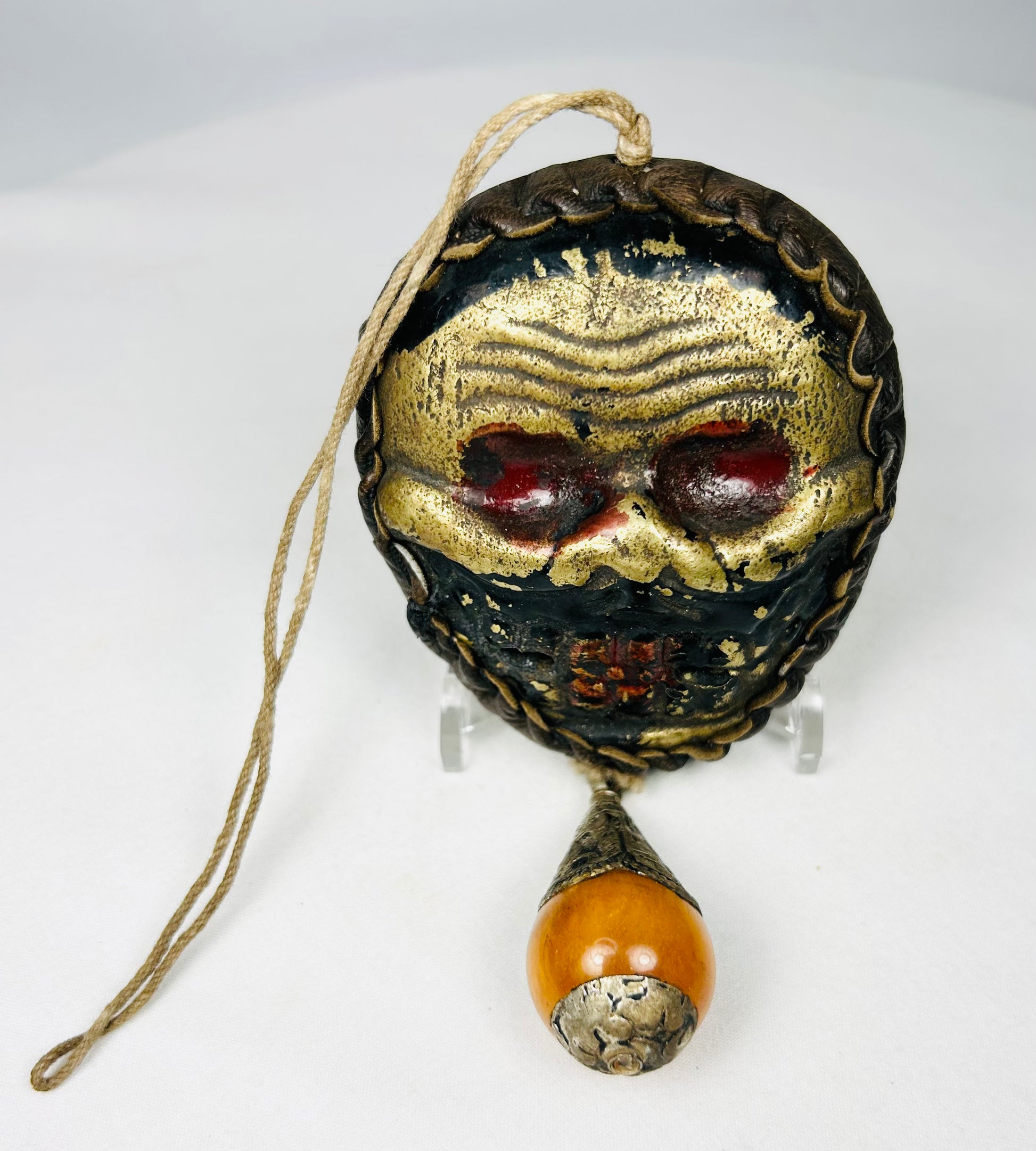 Himalayan skull-form ritual mask with amber-tone bead drop