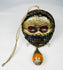 Himalayan skull-form ritual mask with amber-tone bead drop