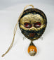 Himalayan skull-form ritual mask with amber-tone bead drop
