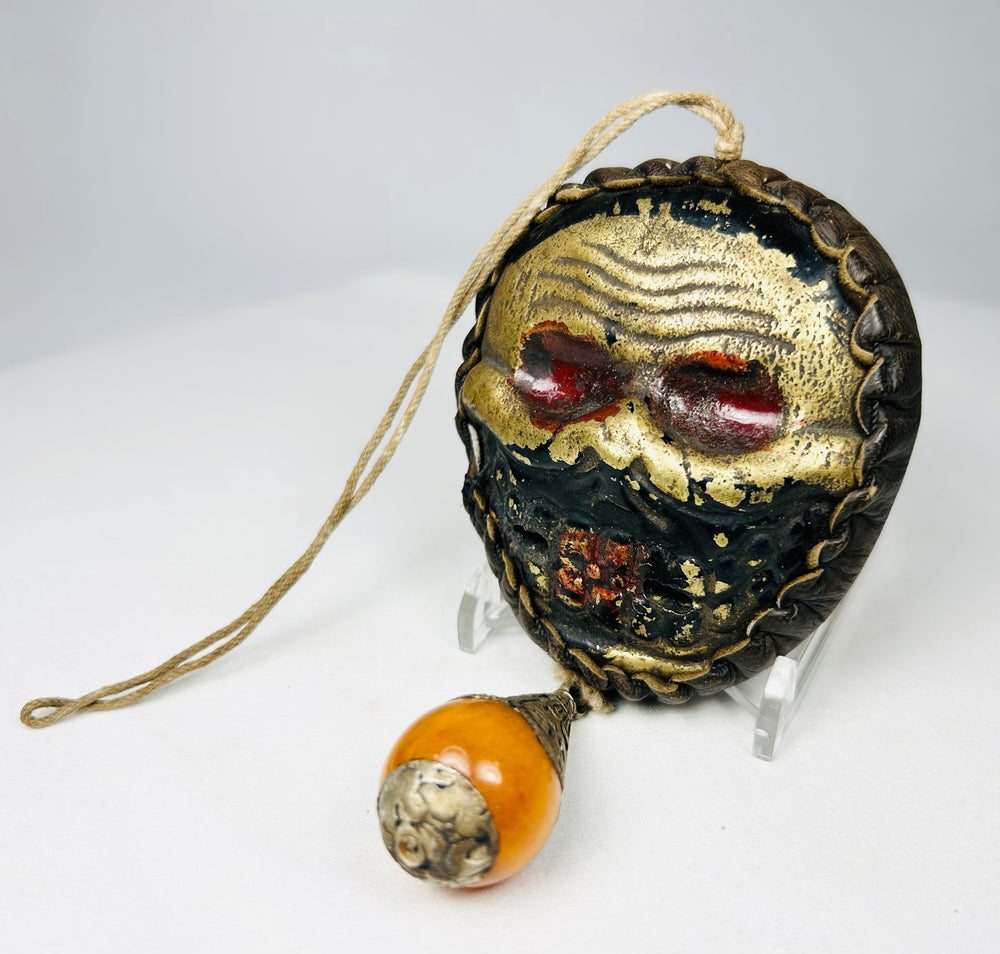 Himalayan guardian mask with leather border and hanging ornament