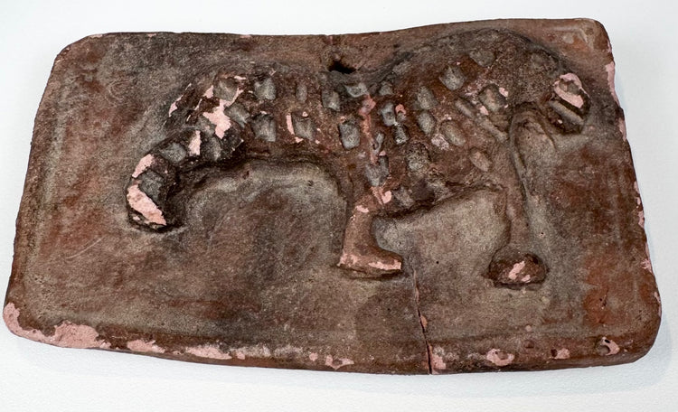 Ancient Indian feline relief plaque in reddish terracotta with suspension perforation and archaeological surface wear.