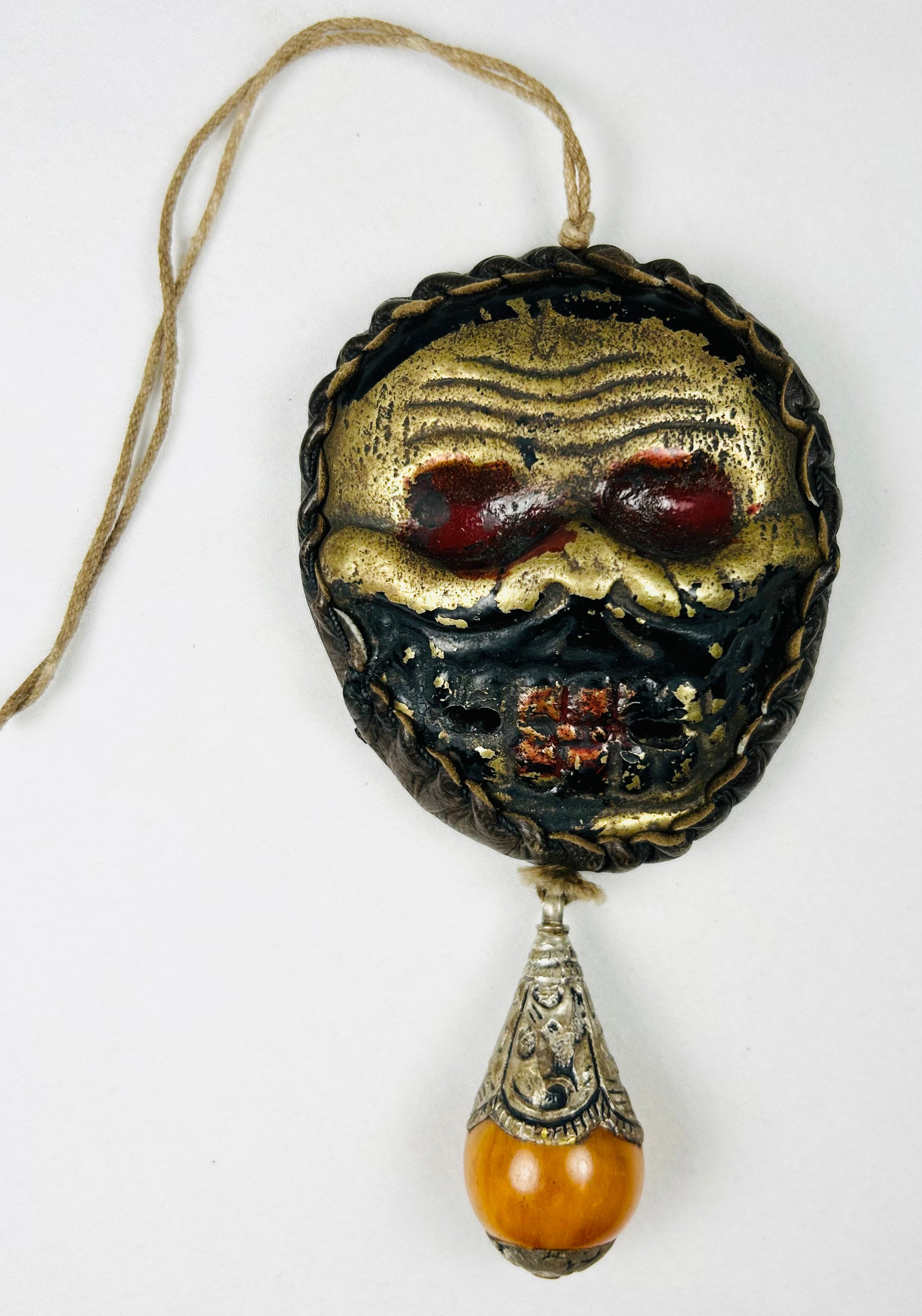 Tibetan Buddhist guardian mask pendant with suspension cord
