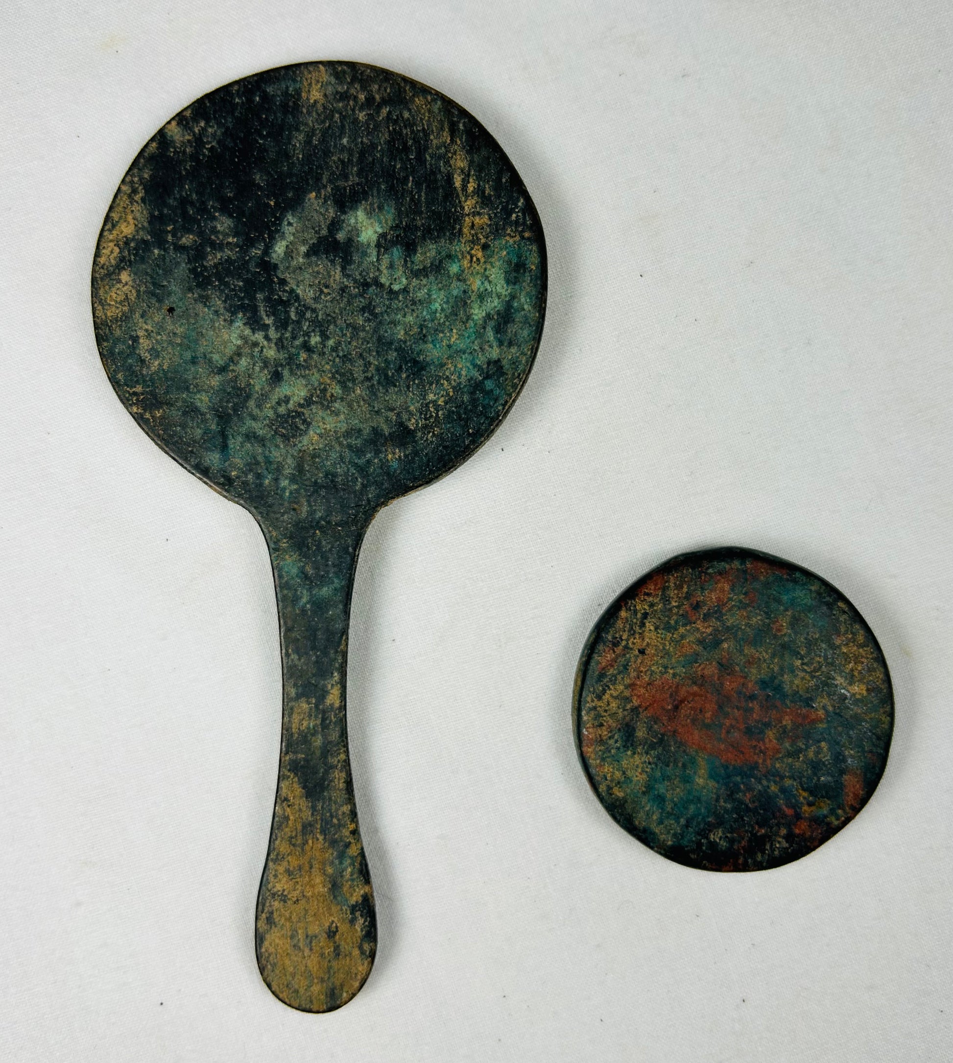 Pair of Chinese bronze mirrors with natural aged patina and relief designs