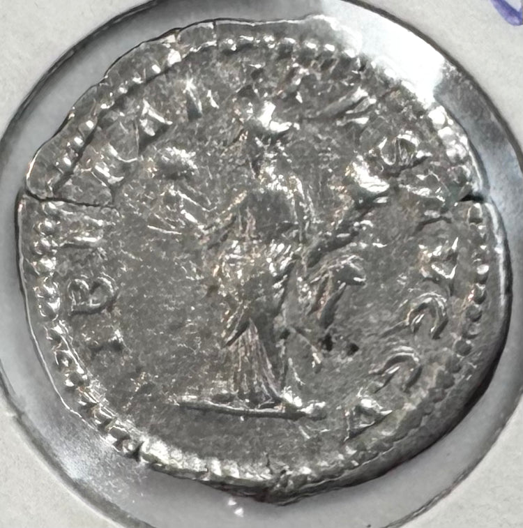 Reverse of a Roman silver denarius of Septimius Severus with standing figure, surrounding legend and preserved silver surface.