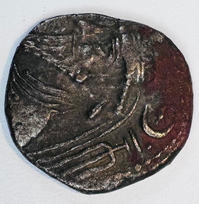 Close-up of an ancient Kingdom of Elymais coin with stylized royal imagery, crescent symbol and dark aged patina.