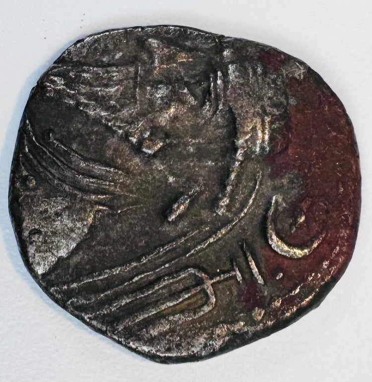 Close-up of an ancient Kingdom of Elymais coin with stylized royal imagery, crescent symbol and dark aged patina.