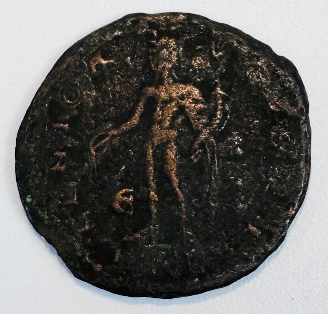 Close-up of an unidentified ancient copper-alloy coin showing a standing human figure and heavily patinated surface.