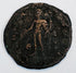 Close-up of an unidentified ancient copper-alloy coin showing a standing human figure and heavily patinated surface.