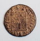Close-up of a Late Roman copper-alloy camp-gate type coin, likely Constantinian era, with fortified gateway reverse.