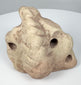 Ancient Greater Antilles trigonolith with pronounced central point and weathered pale stone surface.