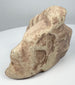 Pre-Columbian Caribbean stone zemi with three-pointed profile and pale cream limestone surface.