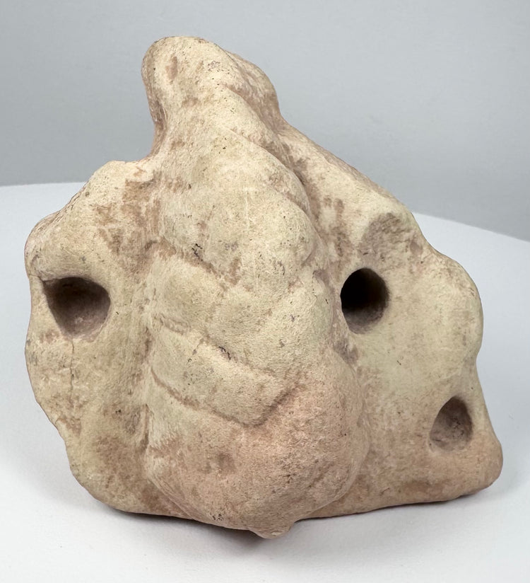Ancient Caribbean three-pointed stone zemi with sculpted base, central projection, and carved recesses.