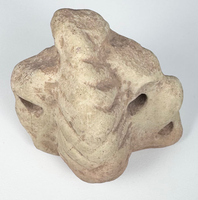 Taíno carved stone ritual sculpture with cream, buff, and pinkish coloration and aged surface wear.