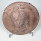 Ancient Greek terracotta female portrait medallion with raised relief, irregular rim, and plain reverse.