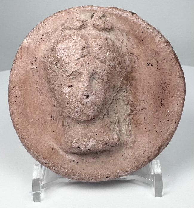 Ancient Eastern Mediterranean terracotta appliqué with idealized female head, possibly from an Asia Minor workshop tradition.