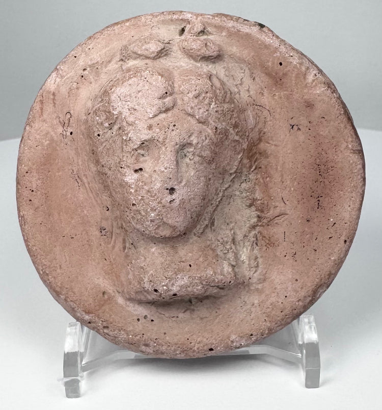 Ancient Eastern Mediterranean terracotta appliqué with idealized female head, possibly from an Asia Minor workshop tradition.