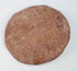 Reverse of a Hellenistic Greek terracotta female bust medallion showing the plain flattened back, aged pinkish-buff surface, mineral deposits, and edge wear.