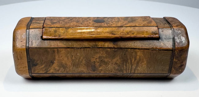19th-century burr walnut tobacco snuff box with hinged cover, rounded terminal sections, and natural wood figuring.
