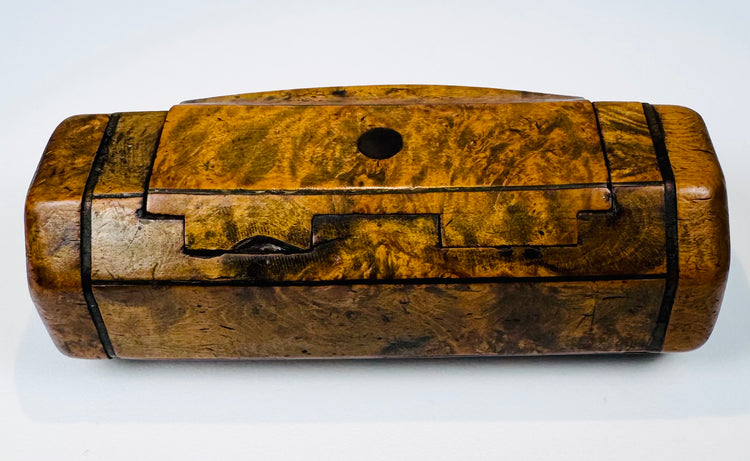 British 19th-century wooden snuff box with figured walnut grain, hinged top, and small circular dark inset.