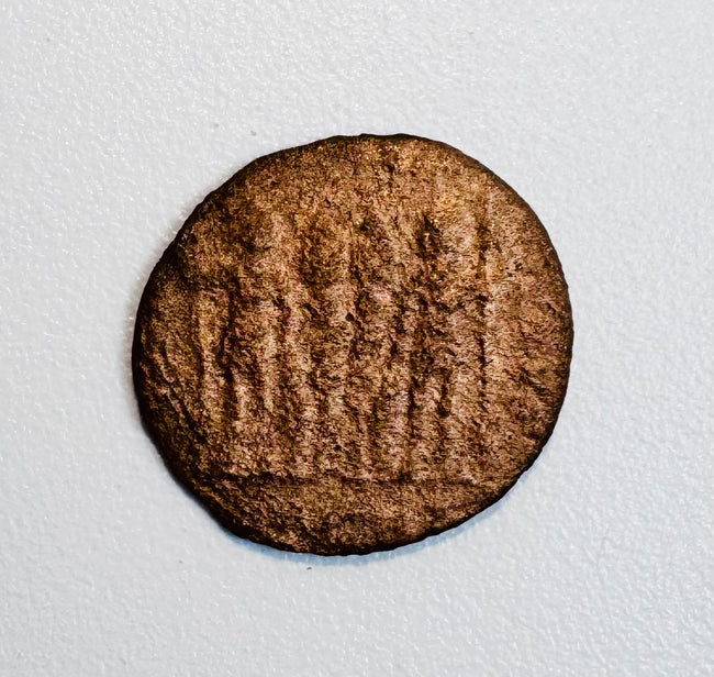 Late Roman bronze coin with worn architectural reverse, possibly a Constantinian camp-gate type, and naturally aged brown patina.