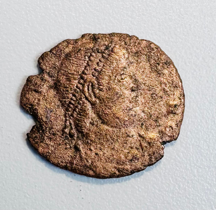 Ancient Late Roman bronze coin with right-facing emperor portrait, irregular flan, partial legend, and reddish-brown patina.
