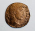 Ancient Roman bronze coin with right-facing imperial bust, surviving Latin legend, and heavily worn reddish-brown surface.
