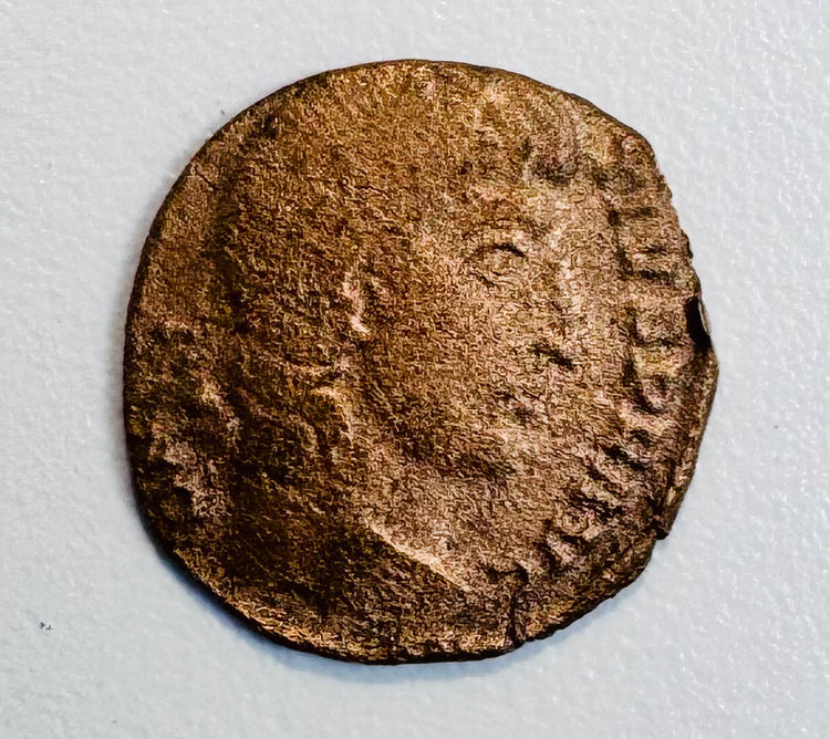Ancient Roman bronze coin with right-facing imperial bust, surviving Latin legend, and heavily worn reddish-brown surface.