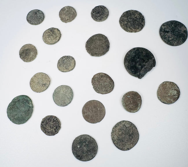 Ancient bronze coin collection showing heavily patinated surfaces, irregular edges, and surviving traces of imperial and reverse designs.
