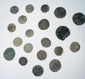 Mixed group of Roman Imperial and possible early Byzantine copper-alloy coins with worn portraits, inscriptions, and mineral encrustation.