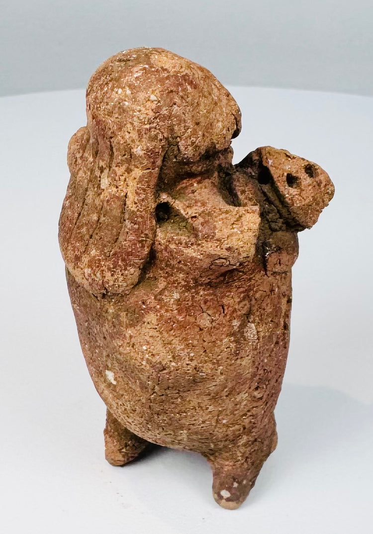 Pre-Columbian Maya terracotta rattle figure showing perforated object held across the abdomen