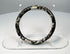 Side view of ancient Roman glass bracelet with thick rounded hoop and mottled mineral deposits
