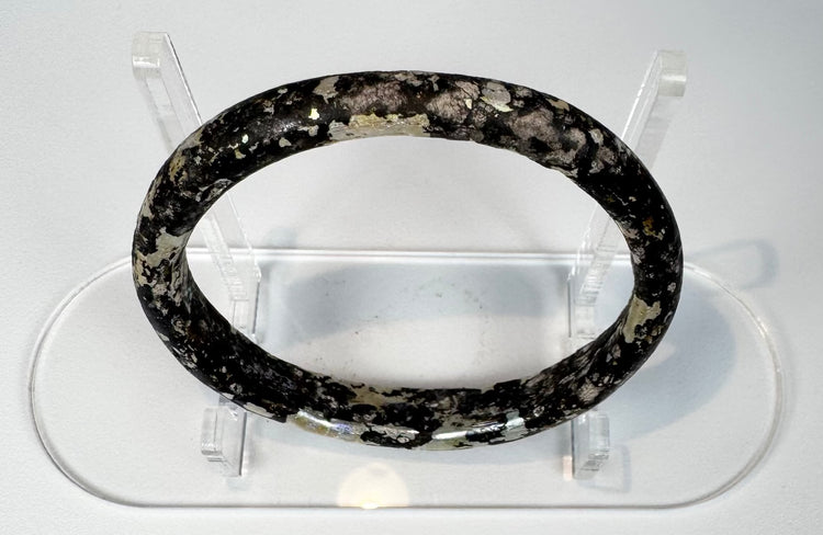 Ancient Roman glass bracelet showing dark cobalt or near-black glass beneath surface weathering