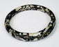 Ancient Roman dark glass bracelet with age-related pitting, dulling, and burial encrustation