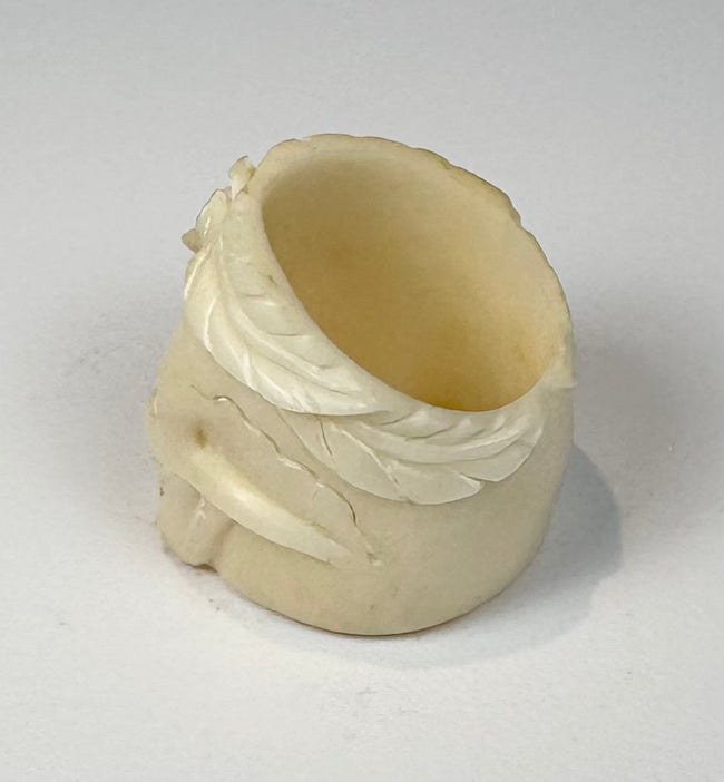 Side view of carved camel bone skull ring showing integrated band and natural fissures