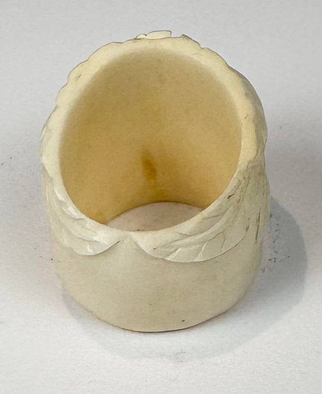 Hand-finished camel bone skull ring with pale cream coloration and carved floral details