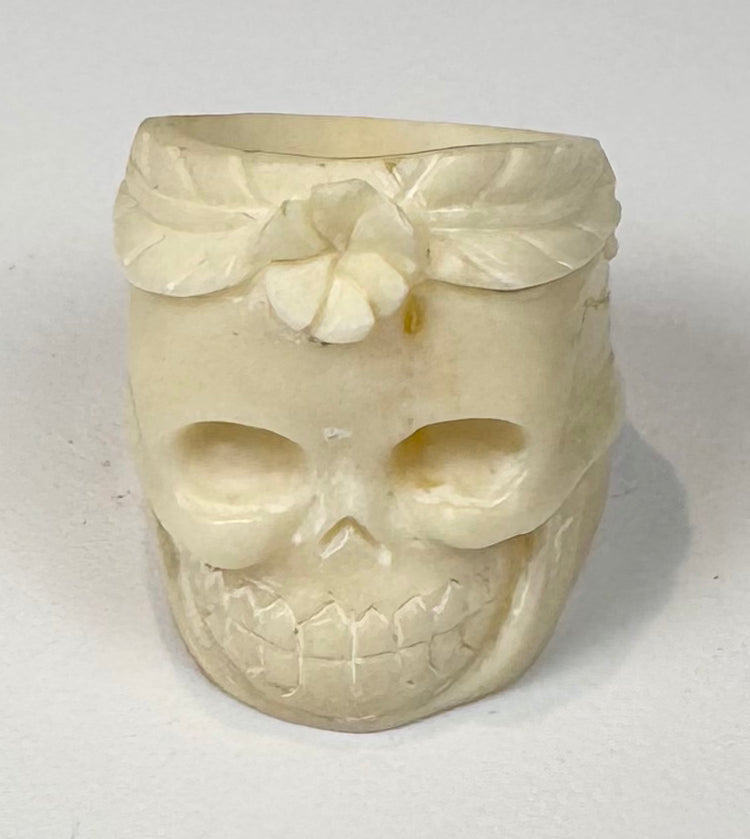 Sculptural skull ring in carved camel bone with deep eye sockets and incised teeth